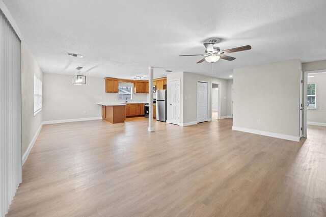 4905 Toni Ave, Lakeland, FL 33812 - unfurnished living room with a ceiling fan and light wood finished floors
