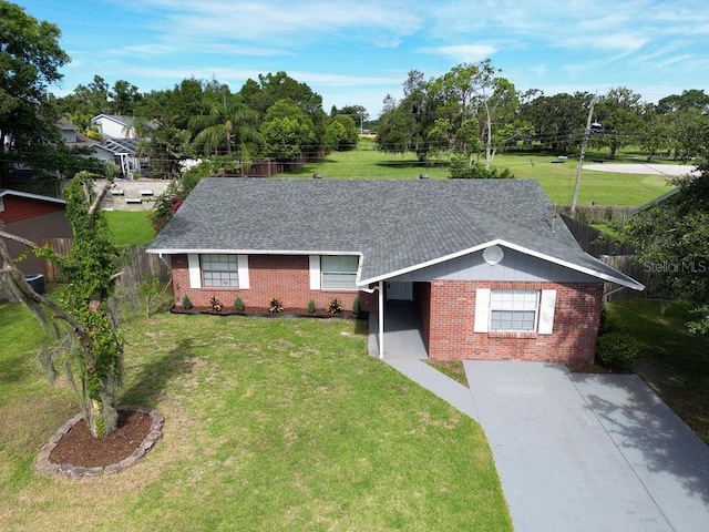 4905 Toni Ave, Lakeland, FL 33812 - ranch-style house with brick siding, roof with shingles, view of scattered trees, and driveway