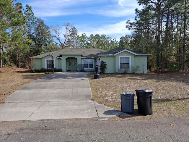 7689 N Galt Pt, Dunnellon, FL 34434 - ranch-style house featuring driveway and stucco siding