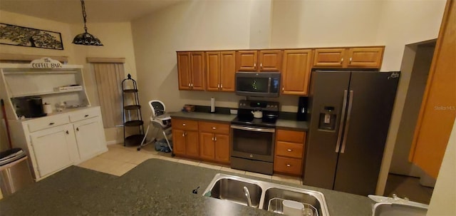 7689 N Galt Pt, Dunnellon, FL 34434 - kitchen featuring stainless steel appliances, dark countertops, brown cabinets, and decorative light fixtures