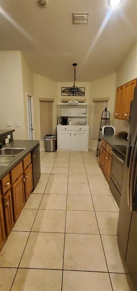 7689 N Galt Pt, Dunnellon, FL 34434 - kitchen with dark countertops, brown cabinets, vaulted ceiling, dishwasher, and light tile patterned floors