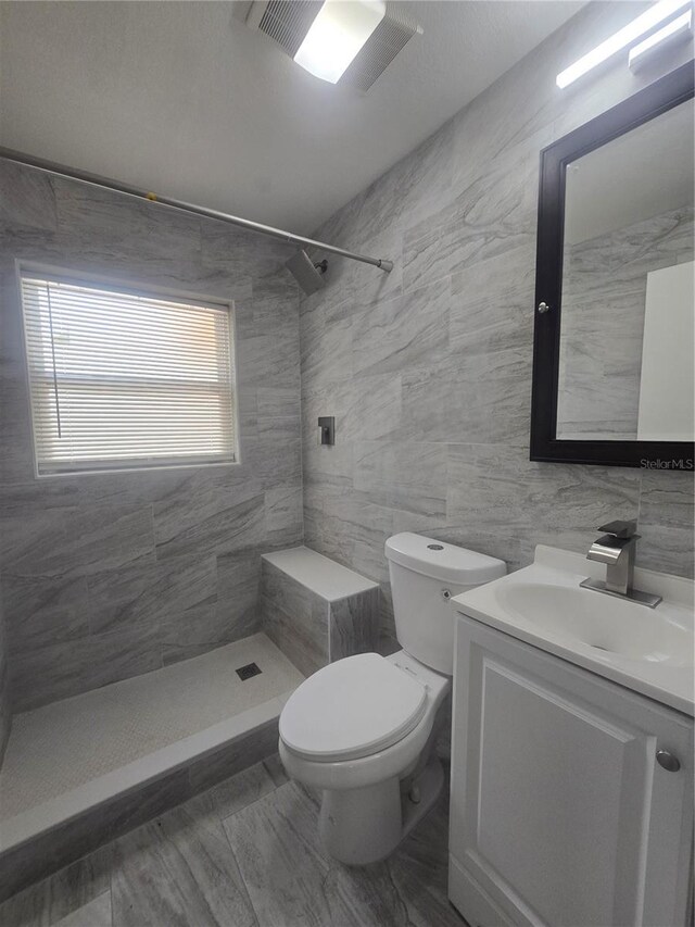 6730 Sandra Dr, Port Richey, FL 34668 - bathroom featuring a tile shower, vanity, and tile walls