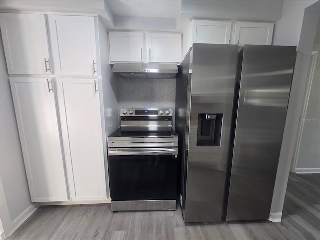 6730 Sandra Dr, Port Richey, FL 34668 - kitchen featuring appliances with stainless steel finishes, ventilation hood, light wood-type flooring, and white cabinets