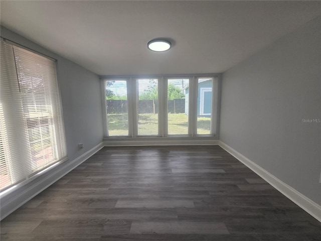 6730 Sandra Dr, Port Richey, FL 34668 - empty room featuring plenty of natural light and dark wood finished floors