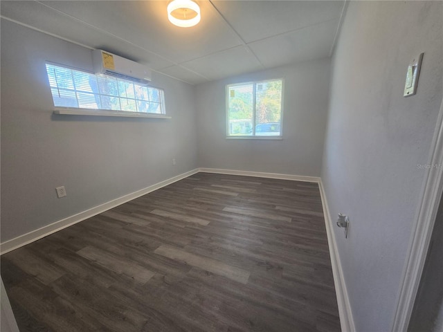 6730 Sandra Dr, Port Richey, FL 34668 - empty room with a wall unit AC, plenty of natural light, and dark wood-type flooring