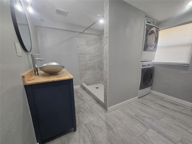 6730 Sandra Dr, Port Richey, FL 34668 - full bathroom featuring stacked washer and clothes dryer, tiled shower, and vanity