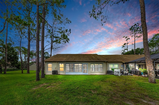 9519 Scenic Pine Ct, New Port Richey, FL 34655 - back of property at dusk featuring a lawn and stucco siding