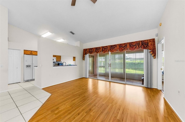9519 Scenic Pine Ct, New Port Richey, FL 34655 - unfurnished living room featuring light wood-style flooring, lofted ceiling, and ceiling fan