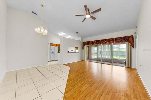 9519 Scenic Pine Ct, New Port Richey, FL 34655 - unfurnished living room with lofted ceiling, ceiling fan, light wood-style flooring, and a chandelier