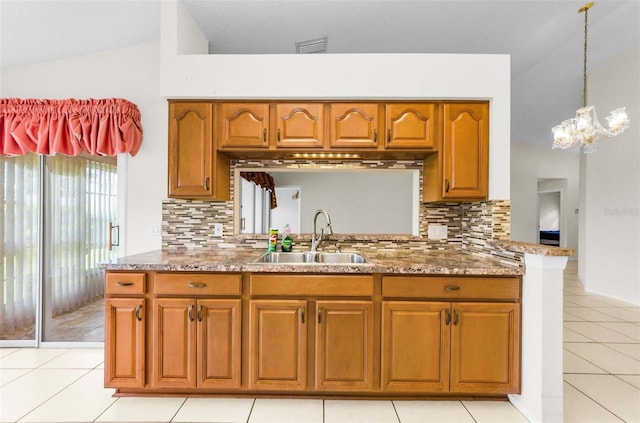 9519 Scenic Pine Ct, New Port Richey, FL 34655 - kitchen with brown cabinets, backsplash, light tile patterned floors, vaulted ceiling, and hanging light fixtures