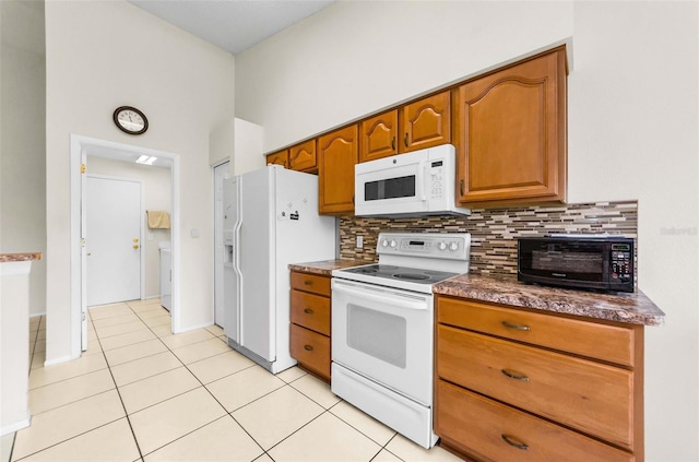 9519 Scenic Pine Ct, New Port Richey, FL 34655 - kitchen featuring white appliances, dark countertops, light tile patterned floors, brown cabinetry, and backsplash
