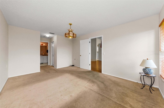 9519 Scenic Pine Ct, New Port Richey, FL 34655 - unfurnished room with a chandelier, carpet floors, and a textured ceiling