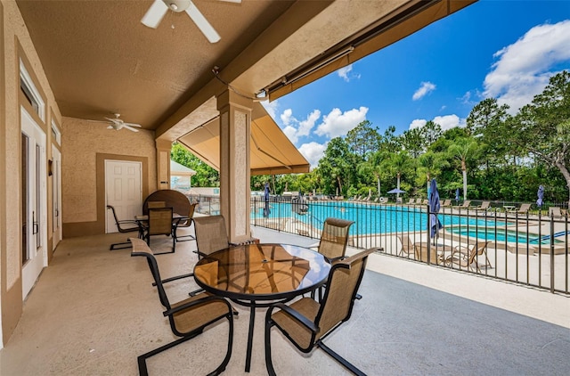 9519 Scenic Pine Ct, New Port Richey, FL 34655 - view of patio featuring a ceiling fan, a community pool, and view of scattered trees