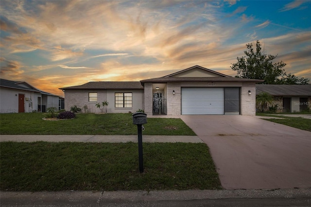 11127 Water Oak Dr, Port Richey, FL 34668 - ranch-style house with concrete driveway, a lawn, and an attached garage