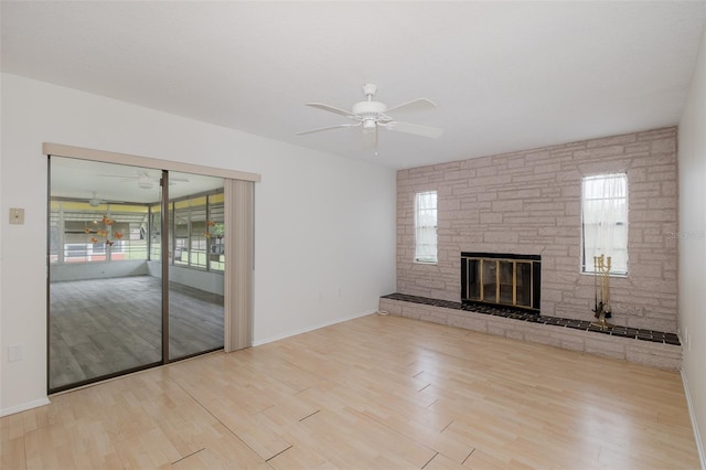 11127 Water Oak Dr, Port Richey, FL 34668 - unfurnished living room featuring a ceiling fan, wood finished floors, and a stone fireplace