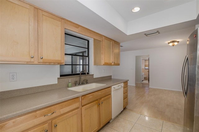 11127 Water Oak Dr, Port Richey, FL 34668 - kitchen with white dishwasher, freestanding refrigerator, light brown cabinetry, light countertops, and light tile patterned flooring