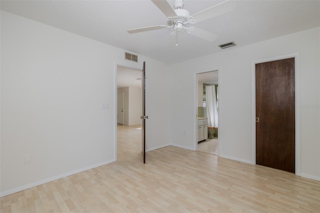 11127 Water Oak Dr, Port Richey, FL 34668 - unfurnished bedroom with light wood-style flooring, ensuite bathroom, and ceiling fan