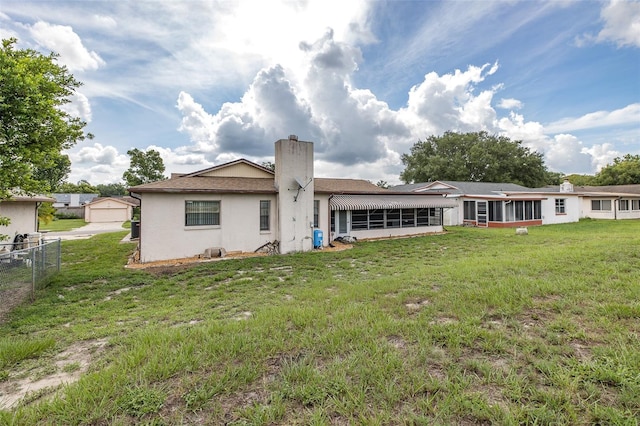 11127 Water Oak Dr, Port Richey, FL 34668 - back of property with a sunroom, a chimney, and stucco siding