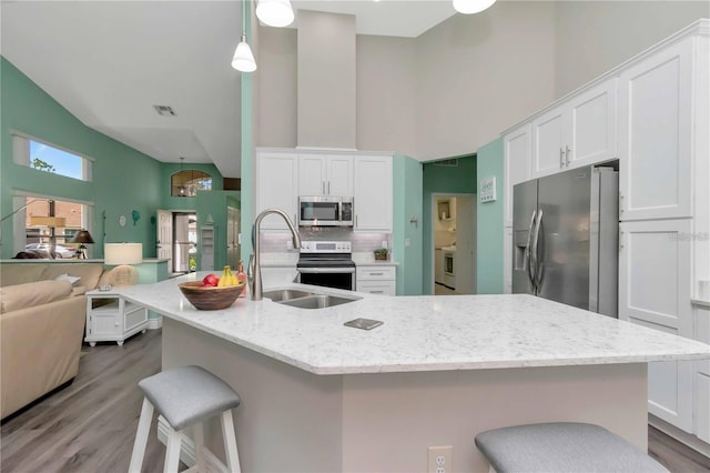 9626 Woodhollow Ct, New Port Richey, FL 34655 - kitchen with stainless steel appliances, high vaulted ceiling, open floor plan, and white cabinetry