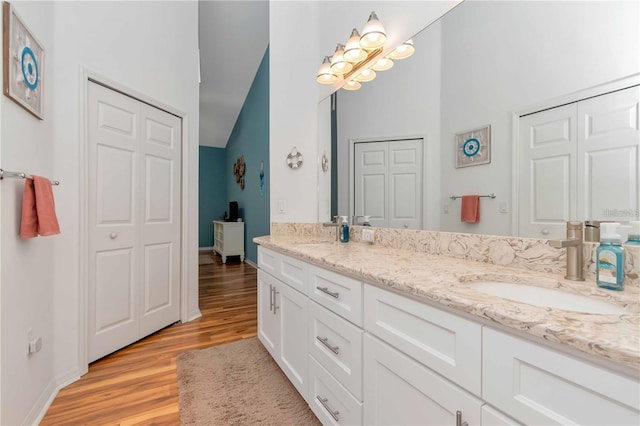 9626 Woodhollow Ct, New Port Richey, FL 34655 - full bath with double vanity, wood finished floors, lofted ceiling, and a closet