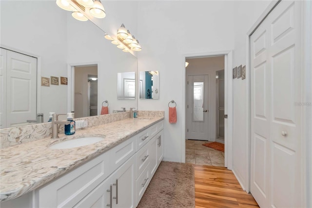 9626 Woodhollow Ct, New Port Richey, FL 34655 - full bath with a closet, double vanity, a towering ceiling, wood finished floors, and a shower with shower door