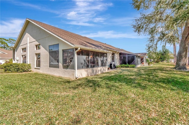 9626 Woodhollow Ct, New Port Richey, FL 34655 - back of house with a sunroom, a yard, and stucco siding