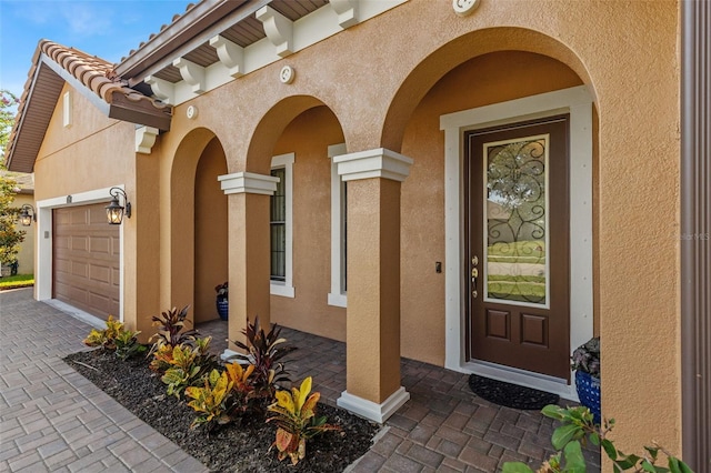 13208 Fawn Lily Dr, Riverview, FL 33579 - view of exterior entry featuring stucco siding, driveway, and an attached garage