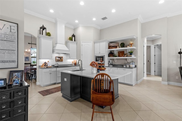 13208 Fawn Lily Dr, Riverview, FL 33579 - kitchen with arched walkways, stainless steel microwave, open shelves, white cabinets, and crown molding