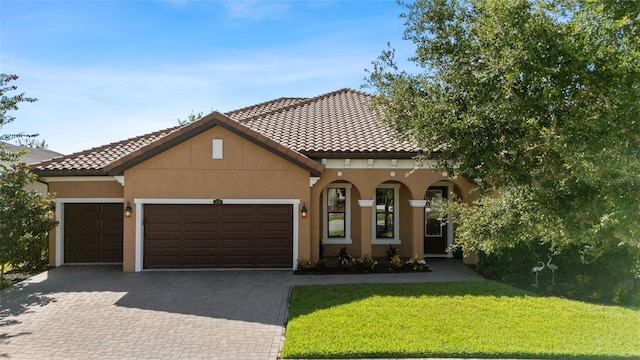 13208 Fawn Lily Dr, Riverview, FL 33579 - mediterranean / spanish house featuring a garage, decorative driveway, a tiled roof, and a front yard