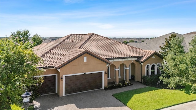 13208 Fawn Lily Dr, Riverview, FL 33579 - mediterranean / spanish home with a garage, decorative driveway, a front lawn, a tile roof, and stucco siding
