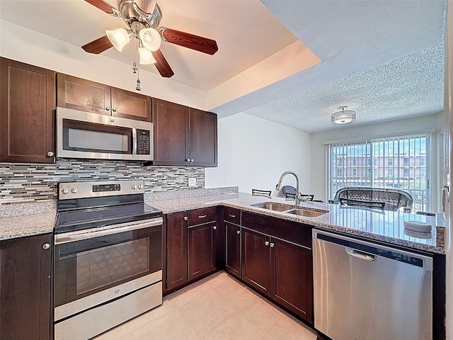 225 Country Club Dr Unit A203, Largo, FL 33771 - kitchen with appliances with stainless steel finishes, backsplash, dark brown cabinets, ceiling fan, and a textured ceiling