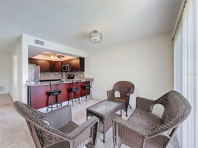 225 Country Club Dr Unit A203, Largo, FL 33771 - sitting room with light carpet, ceiling fan, bar, and a textured ceiling