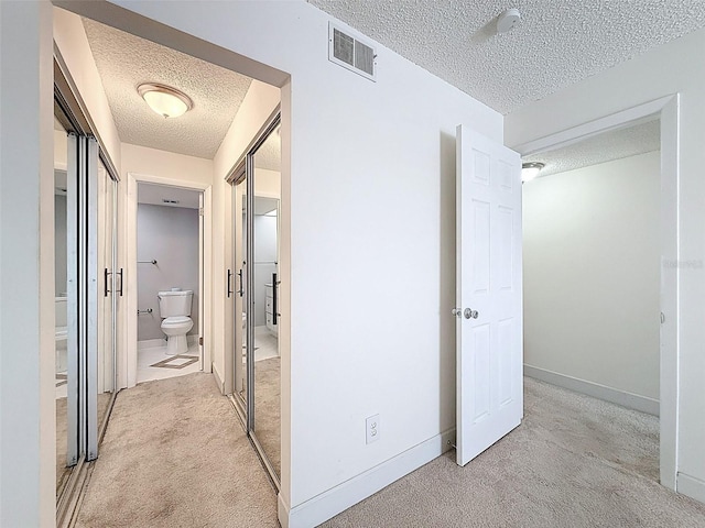 225 Country Club Dr Unit A203, Largo, FL 33771 - hallway with a textured ceiling and light colored carpet