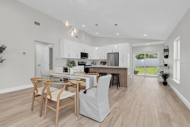 6529 Taylor Ct, New Port Richey, FL 34653 - dining area with light wood finished floors, recessed lighting, and high vaulted ceiling