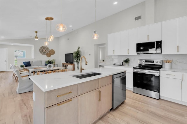 6529 Taylor Ct, New Port Richey, FL 34653 - kitchen with appliances with stainless steel finishes, light countertops, open floor plan, decorative backsplash, and a center island with sink