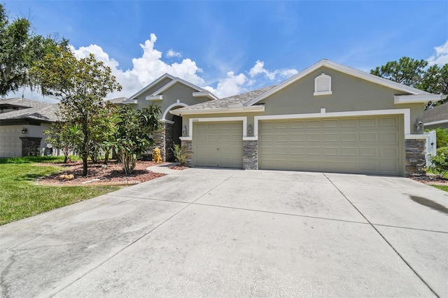 11126 Biddeford Pl, New Port Richey, FL 34654 - view of front of house featuring stone siding, stucco siding, an attached garage, and driveway