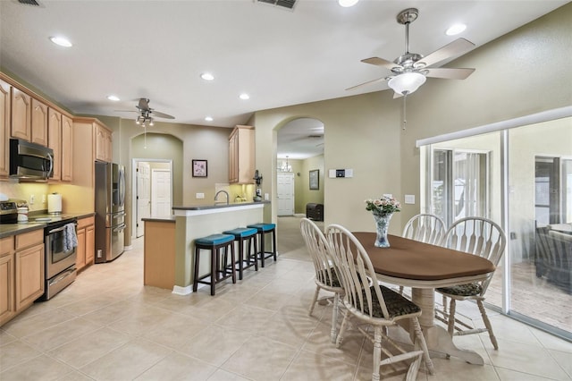 11126 Biddeford Pl, New Port Richey, FL 34654 - dining area featuring ceiling fan, arched walkways, recessed lighting, and light tile patterned flooring
