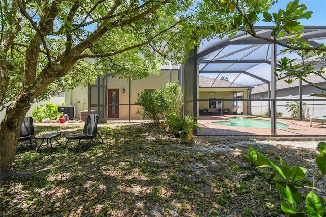 11126 Biddeford Pl, New Port Richey, FL 34654 - rear view of house with a patio area, an outdoor pool, glass enclosure, and stucco siding