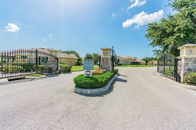 11126 Biddeford Pl, New Port Richey, FL 34654 - view of asphalt street featuring a gate, curbs, a gated entry, and a residential view