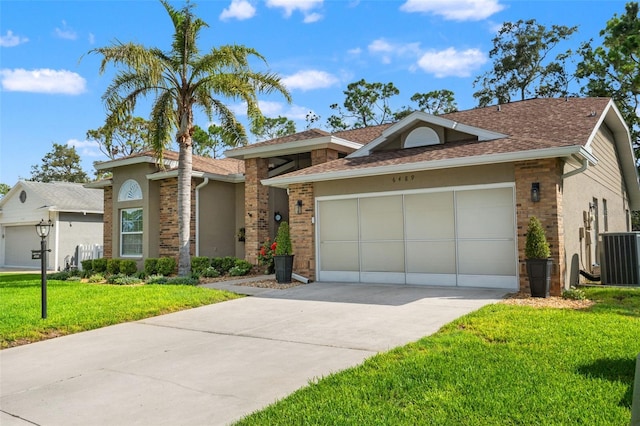 view of front of home with an attached garage, a front lawn, driveway, a shingled roof, and brick siding