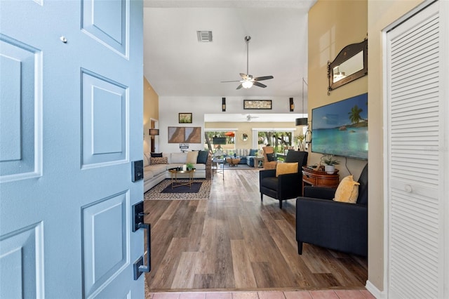 foyer entrance featuring a ceiling fan, high vaulted ceiling, and wood finished floors