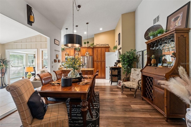 dining area featuring wood finished floors and vaulted ceiling