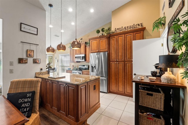 kitchen featuring stainless steel appliances, light stone counters, recessed lighting, a textured ceiling, and hanging light fixtures