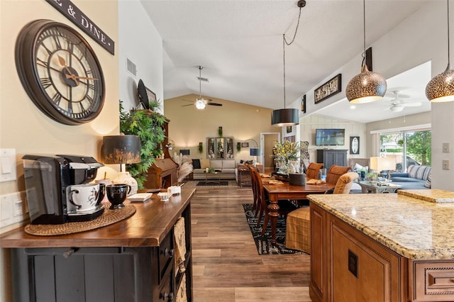 dining space featuring ceiling fan, lofted ceiling, and wood finished floors