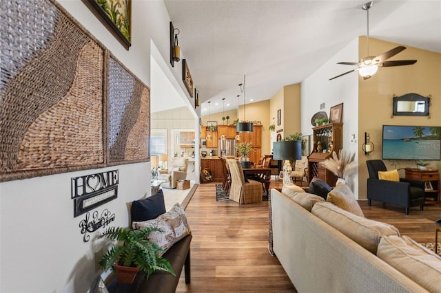 living room featuring wood finished floors, a ceiling fan, and high vaulted ceiling