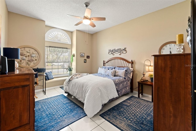 bedroom with light tile patterned flooring, a textured ceiling, and a ceiling fan