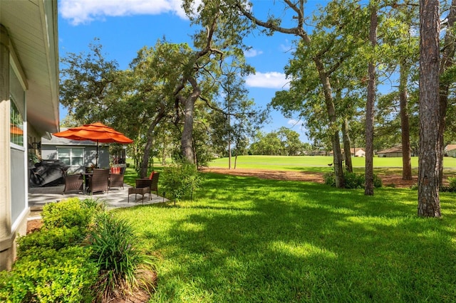view of grassy yard with a patio