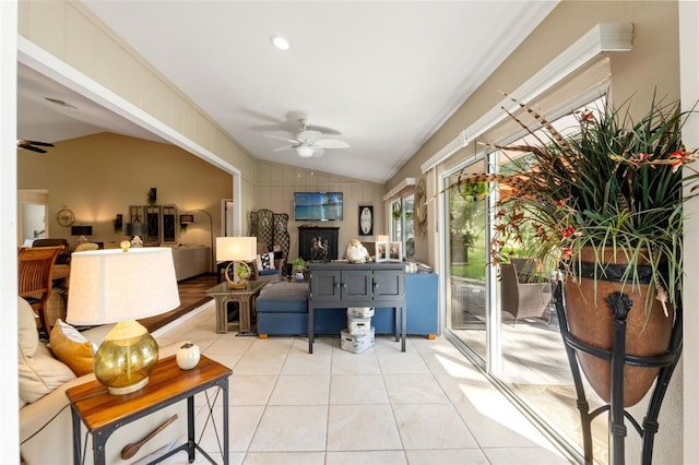 living room featuring ceiling fan, vaulted ceiling, and light tile patterned floors