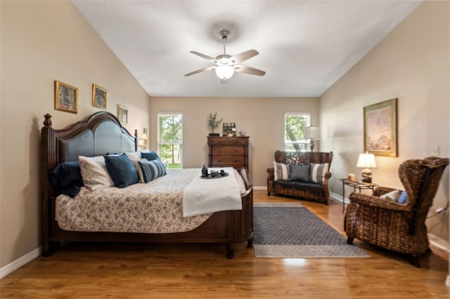 bedroom with lofted ceiling, wood finished floors, and a ceiling fan