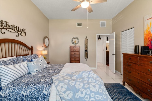 bedroom with tile patterned floors, a ceiling fan, and a textured ceiling